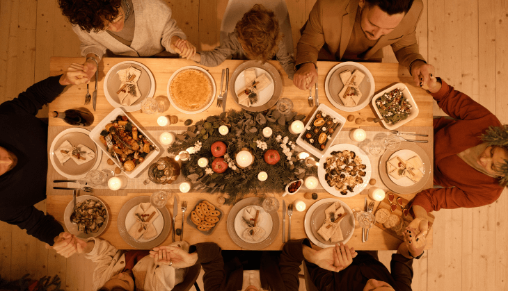 Family gathered around a table preparing to enjoy a holiday meal